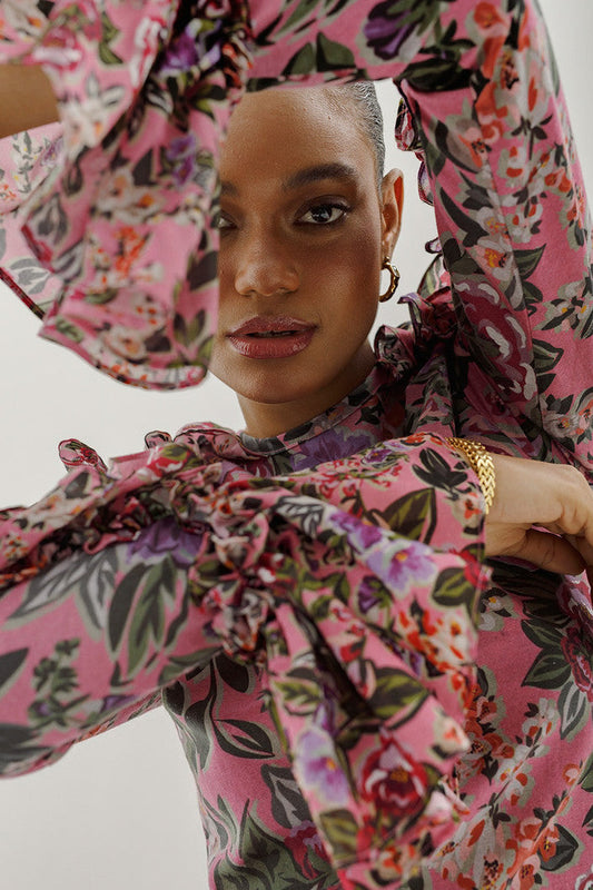 Woman wearing a pink dress with an exclusive floral print fashion featuring tropical and romantic floral patterns