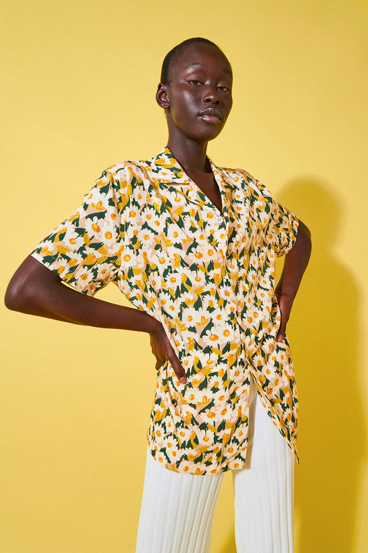 Model wearing bold floral print shirt and white pants showcasing AI fashion print design collaboration