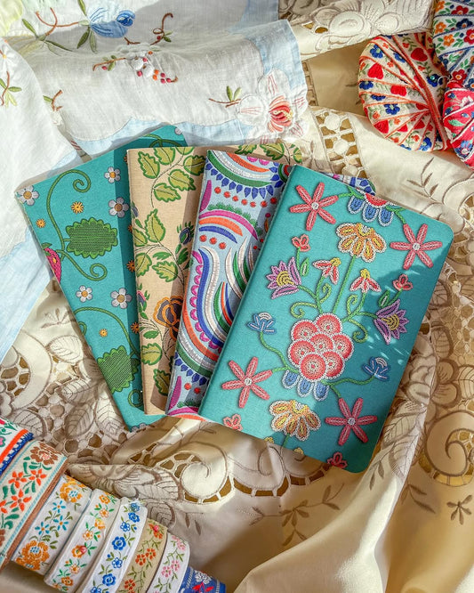 Four exclusive embroidered floral journals from Cícero Papelaria’s D@.vez collection by Hanna Inaiáh